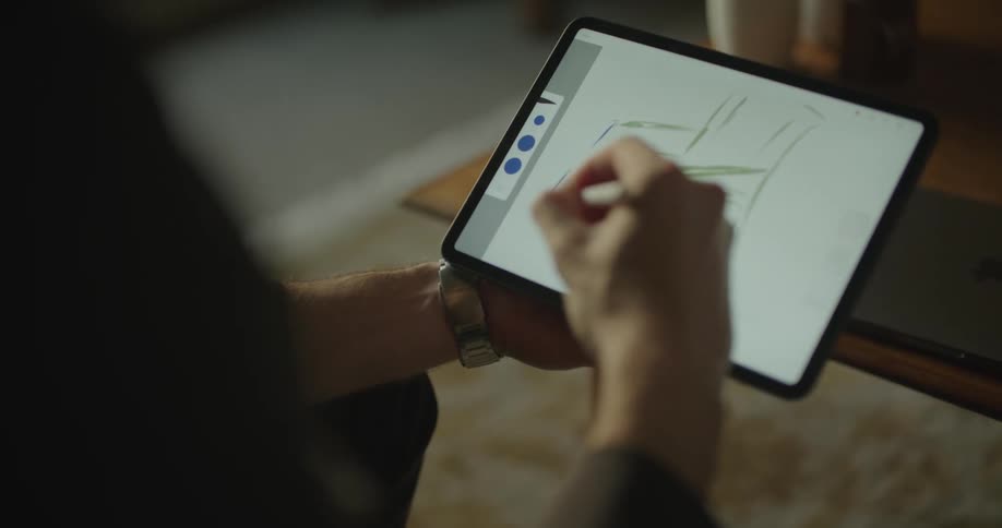 A man writing on a tablet computer