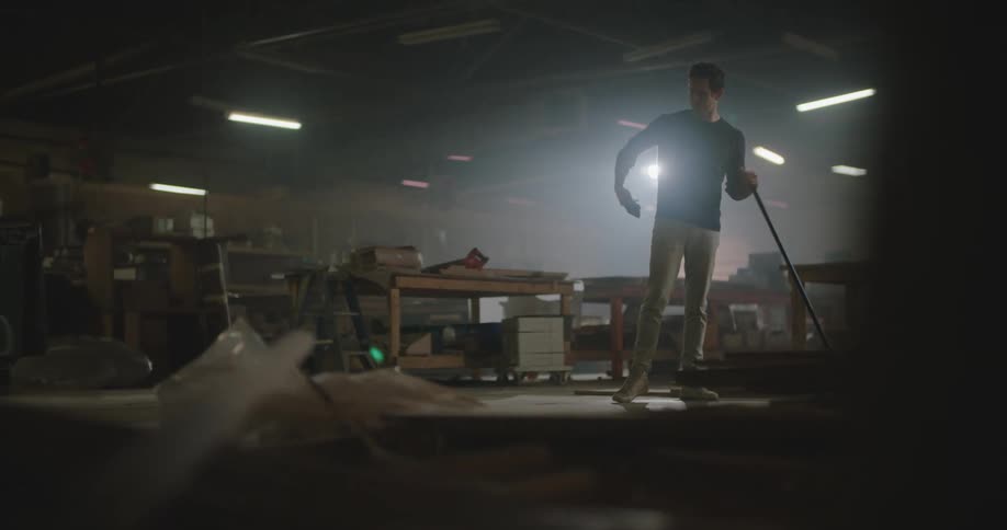 A man is sweeping up the warehouse