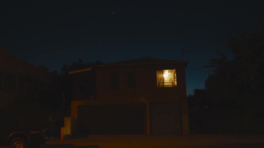 Yellow light coming out of the window of a house at night