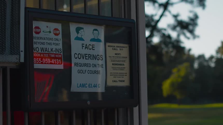 Face mask warnings are displayed on a wall in a public space
