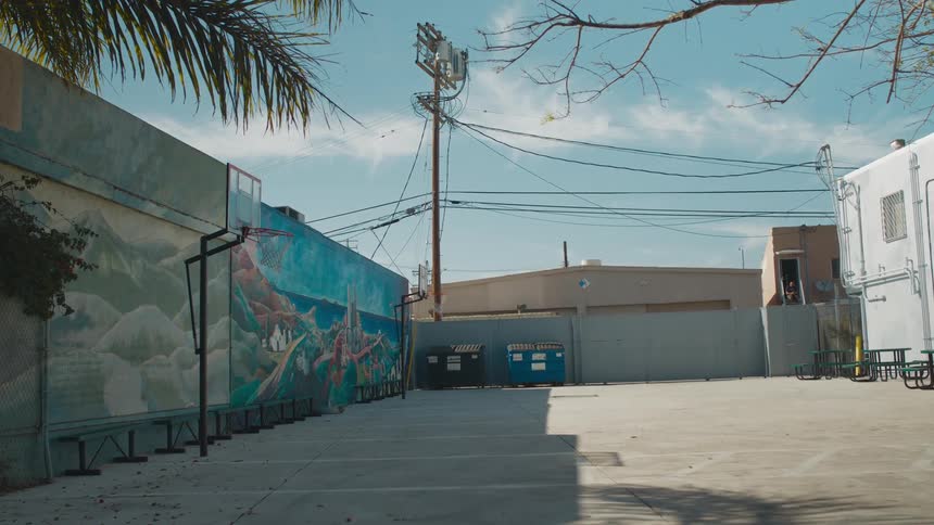 Basketball hoop on the parking lot behind a building at daytime