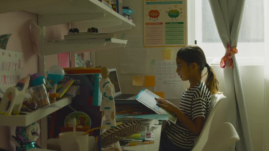 Girl doing homework in her bedroom at home