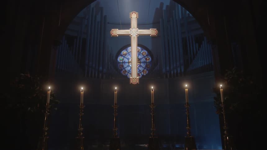 Candles lit in front of a lit up cross at a church