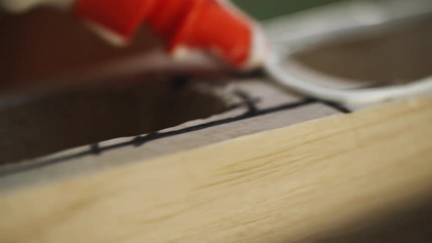 Person uses glue on wood
