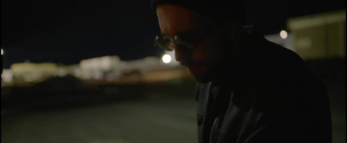 A man is standing outdoors at night