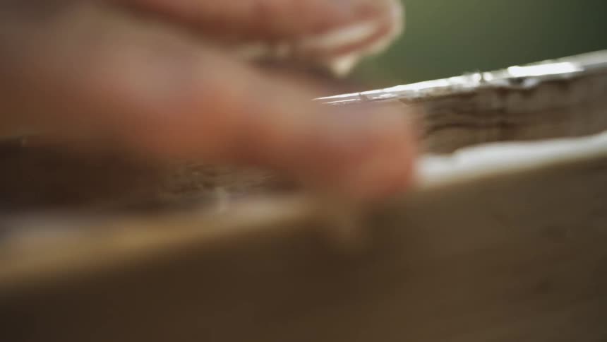 Person putting glue on wood