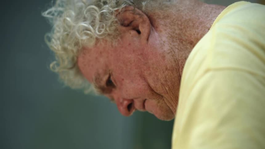 A man in a room with a wall in the background