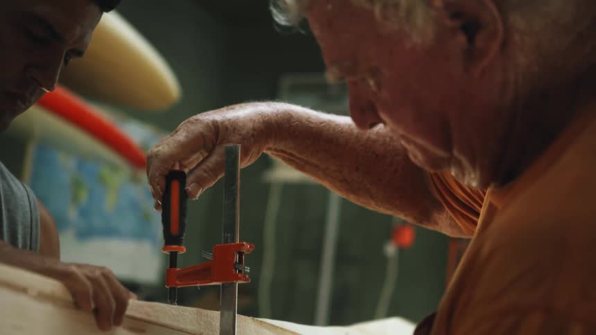 Craftsman carpenter clamping a piece of wood in the workshop