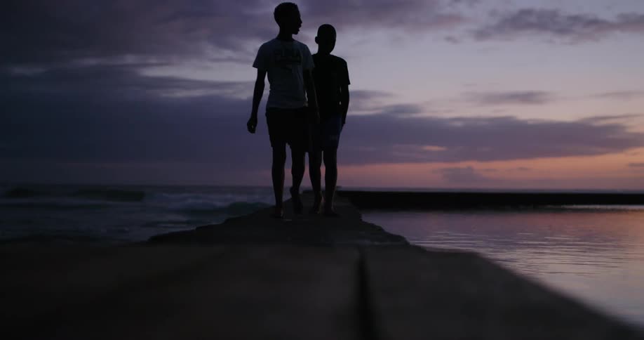 Two boys walk along the pier