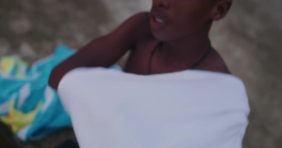 A man taking off his shirt at the beach