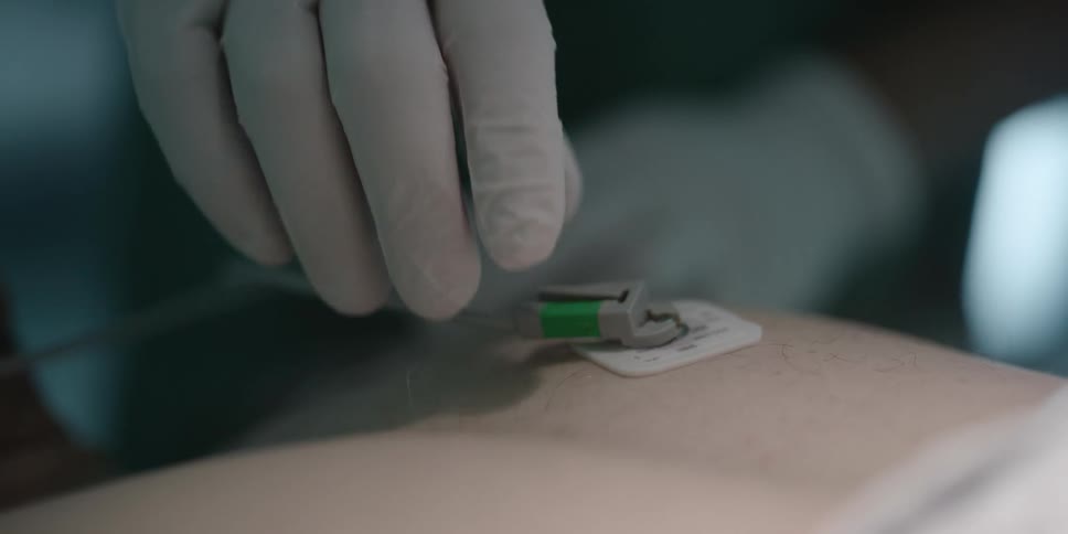 A person attaching a sensor to another person