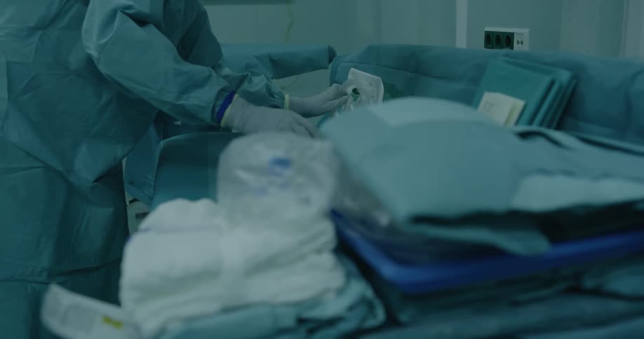 A nurse sets up medical equipment in a room