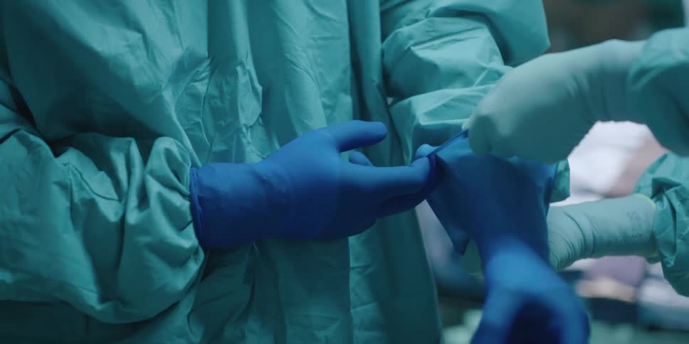 Doctors in a hospital putting on gloves