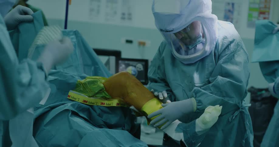 A group of doctors are peforming surgery on someones leg