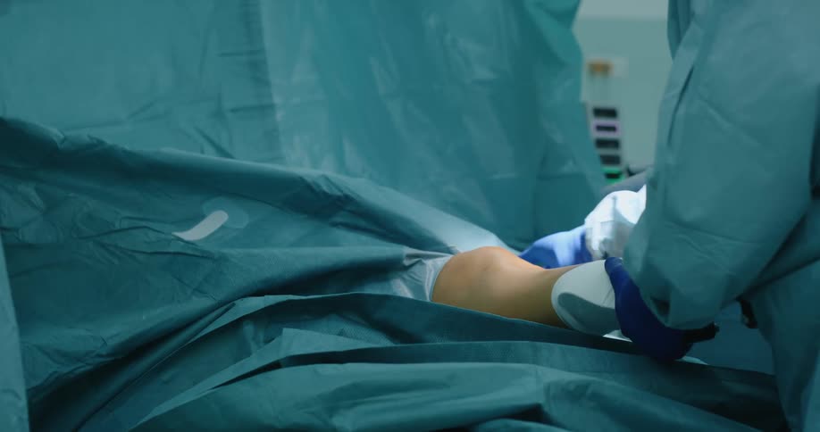 Surgeons enveloping a patient with surgical cloth inside a surgery room