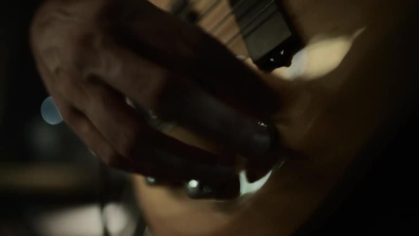 A man adjusts his guitar