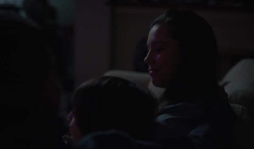Two people sitting on a couch watching tv