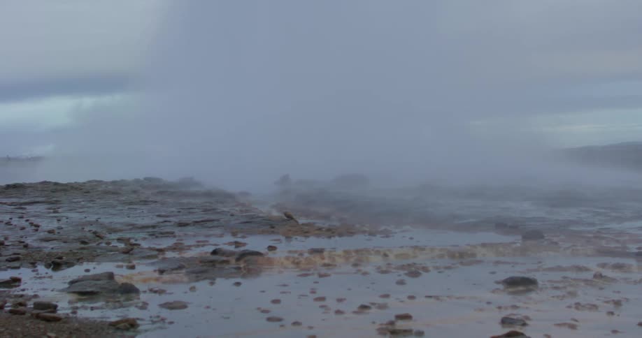 Water geyser erupts leaving a cloud of mist in the evening