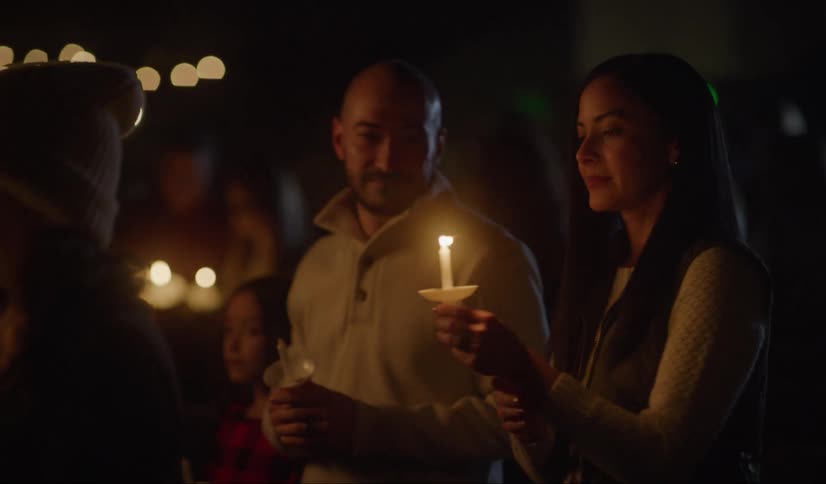 Family standing at night on a vigil event lighting candles