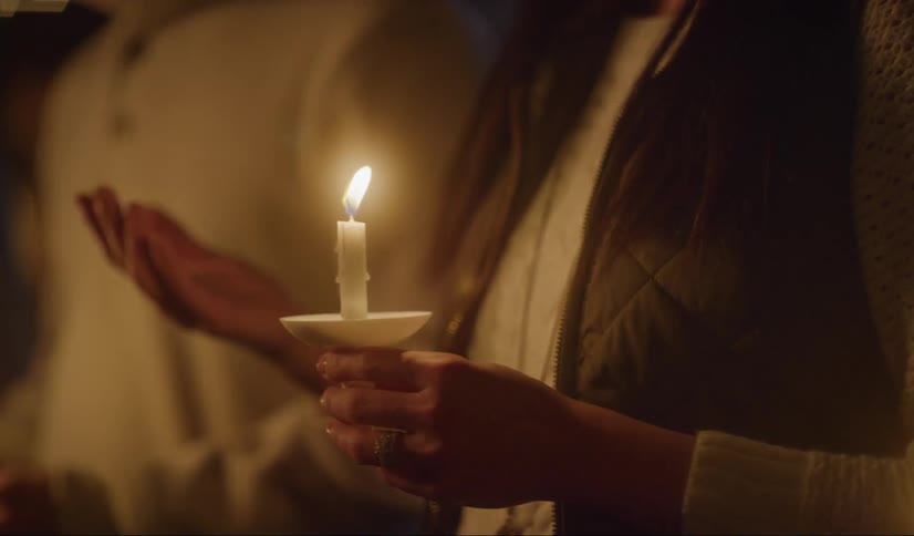Couple holding candles in their hands praying on a vigil at night