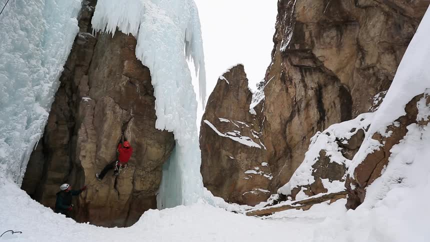 Two rock climbers in a snowy setting