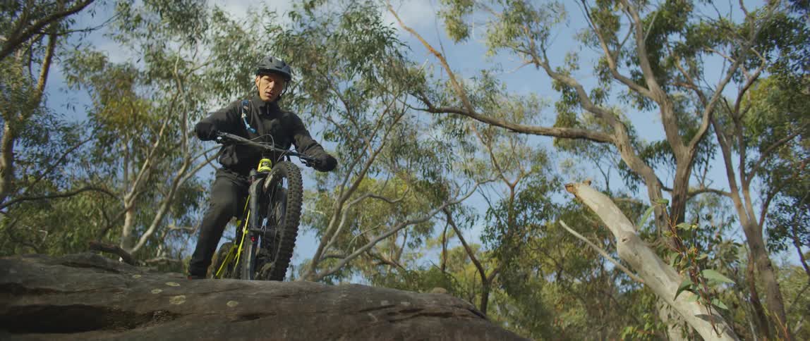 A man is mountain biking in a forest