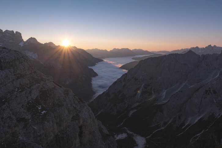 River flowing between mountains as the sun rises