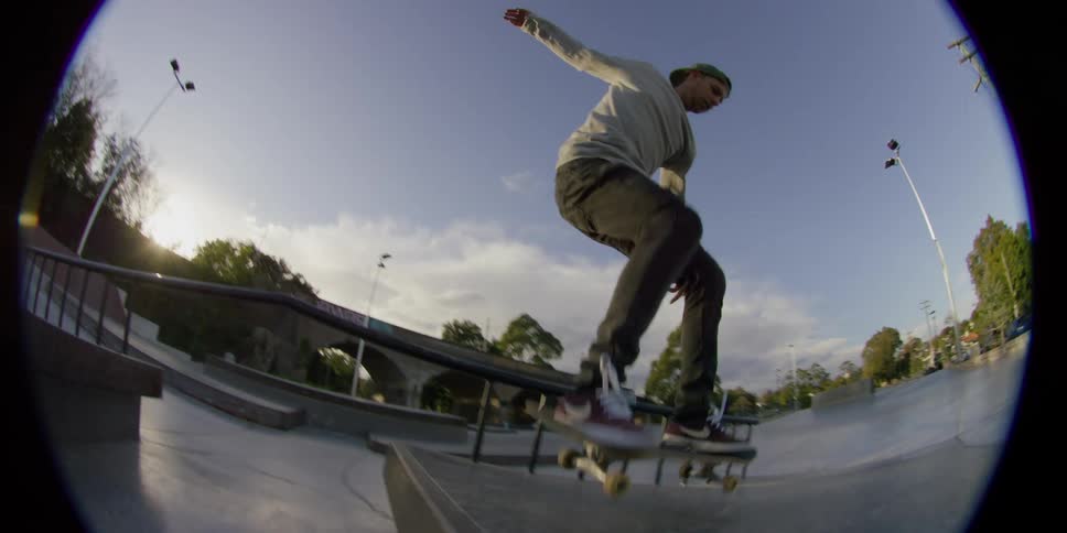 A man is skateboarding at a park in spring