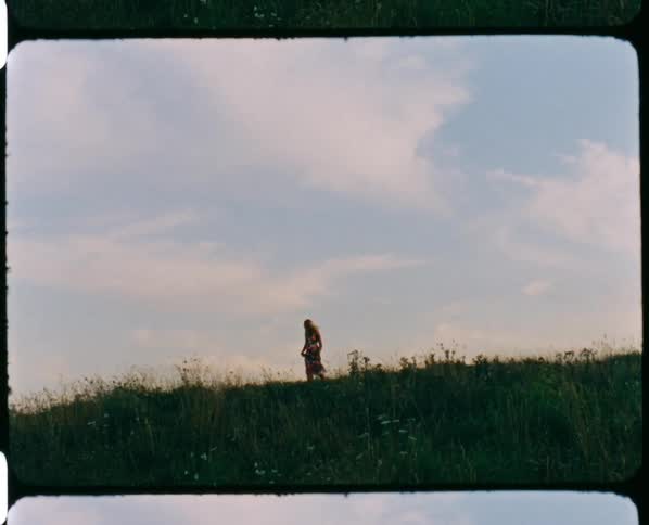 A woman is walking back and forth on the hill