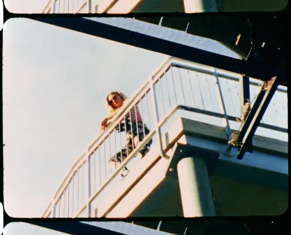 Vintage film of a woman leaning against a railing on a bridge