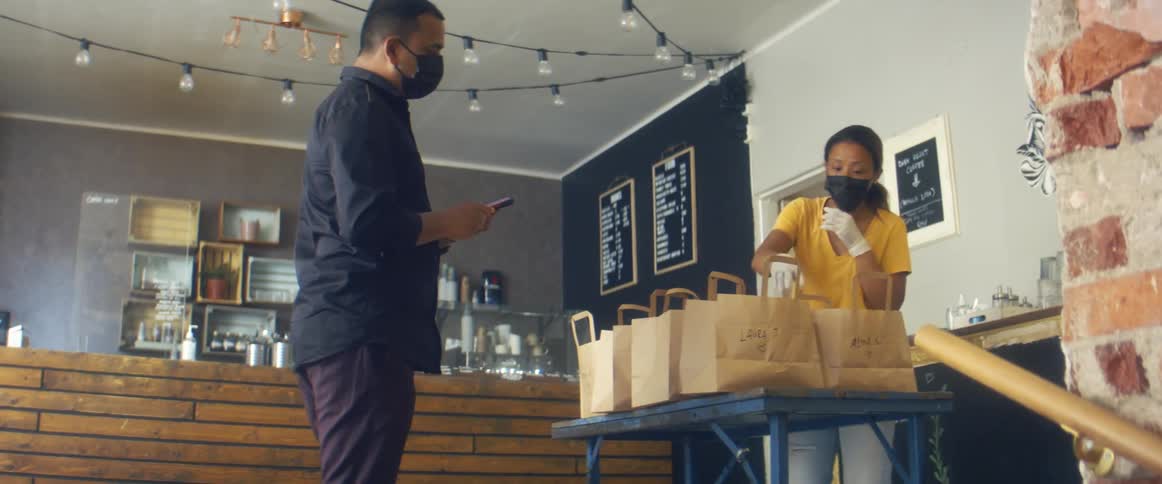 Store owner delivering orders to customer inside the store