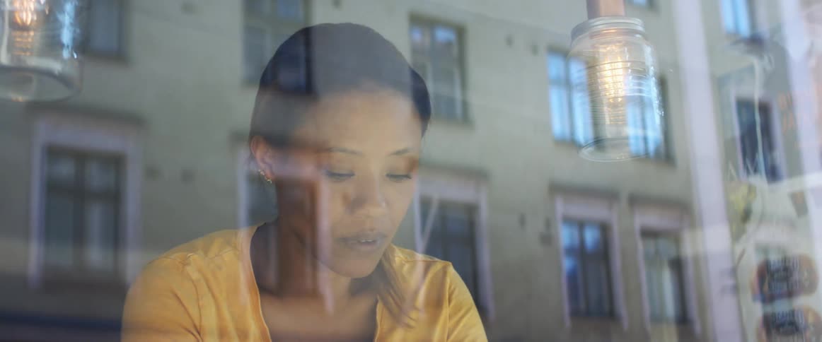 A woman is moving behind the clear glass window