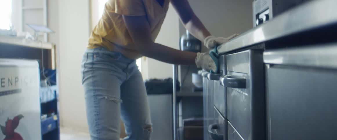 A woman is cleaning her kitchen during the day