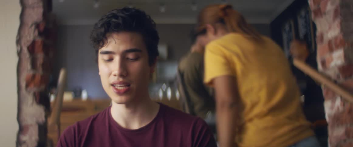 A woman serves coffee to a man in a cafe