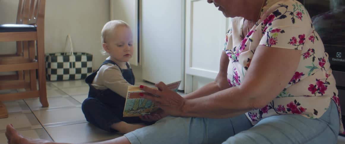 A grandmother reading a book to a child