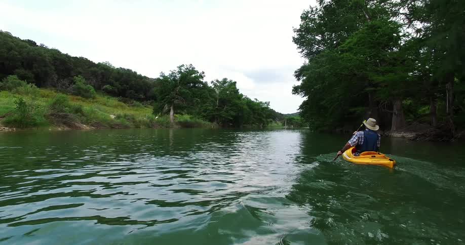 A man is rowing a boat in a stream