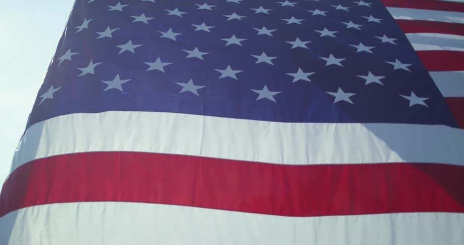 An american flag billowing outside on a sunny day