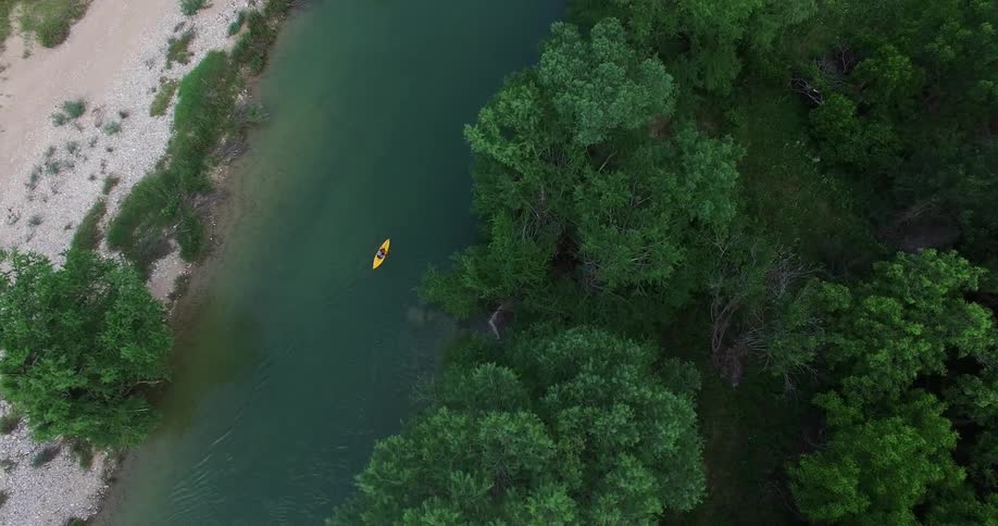 Aerial view of a yellow kayak going down a river