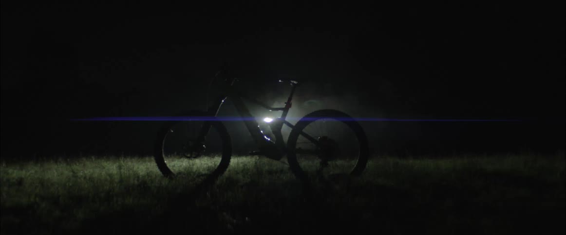 Flashing white light shines on a bicycle on the grass at night