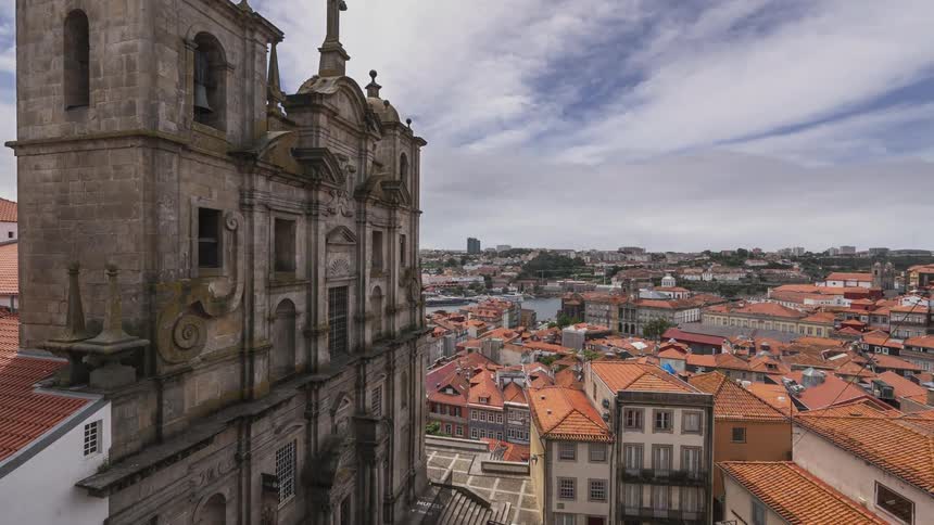 Clouds passing over an old stone building in a town in the daytime