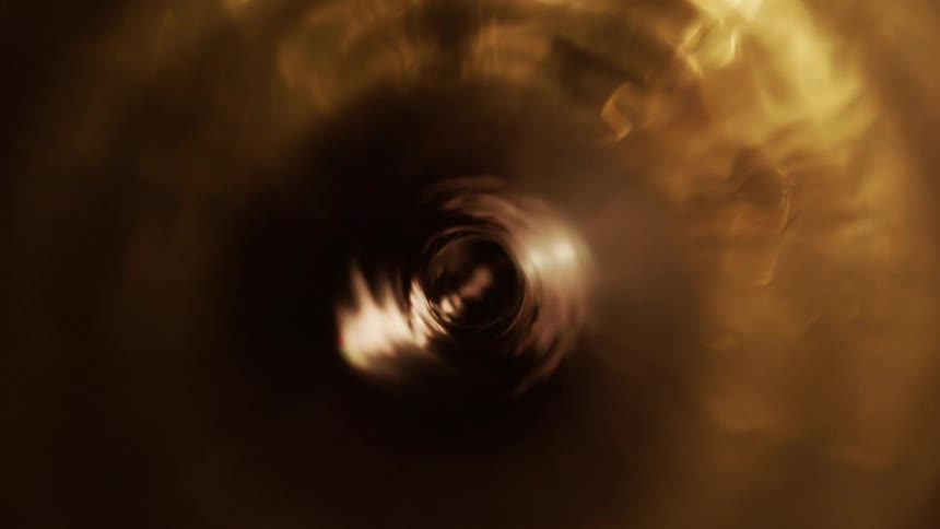 A golden liquid spins rapidly in a centrifuge
