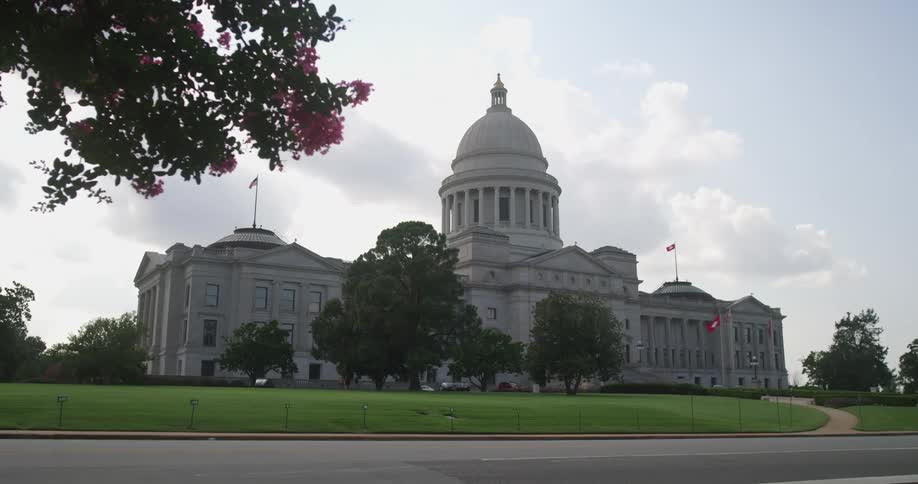 Car drives along street past domed capitol building