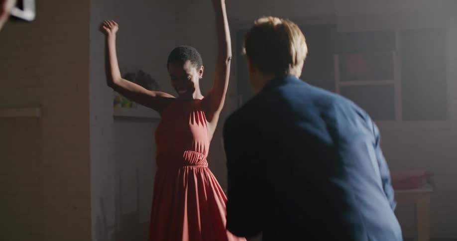 Man filming a young couple dancing inside a room