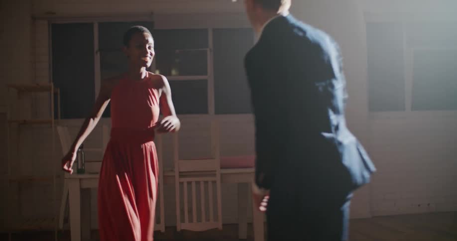 A man and a woman in a room dancing with a wall in the background