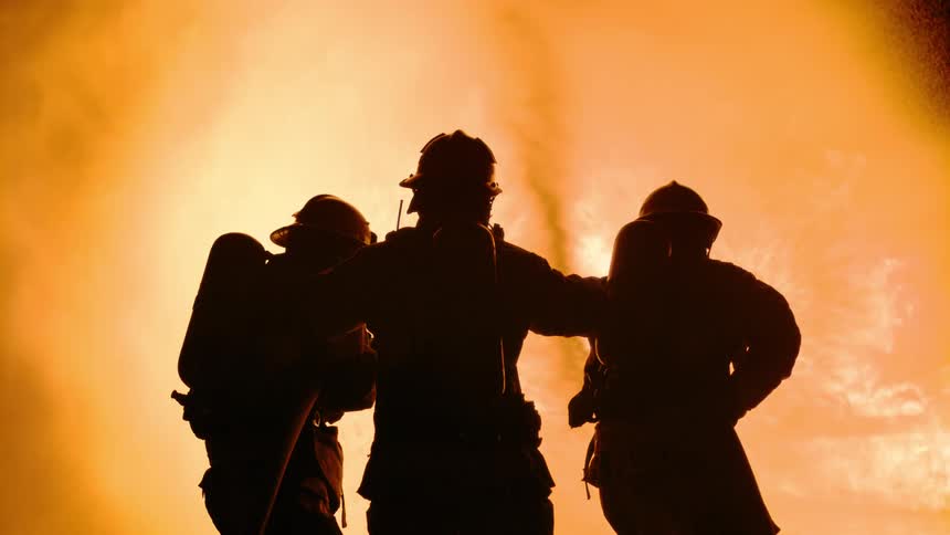 A view of firemen spraying water onto a fire