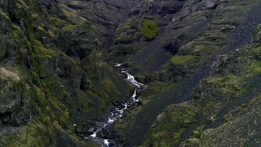Rocks and boulders float above a flowing river in a ravine