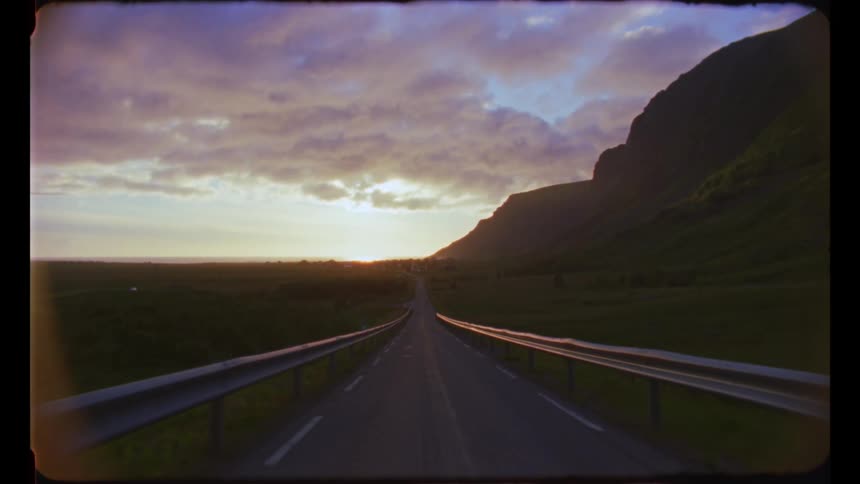 Rural road on the countryside near a mountain at sunset