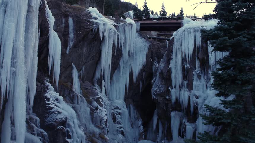 Frozen water falls alongside a cliff