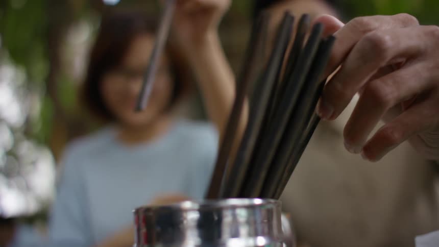 Two people grabbing chopsticks