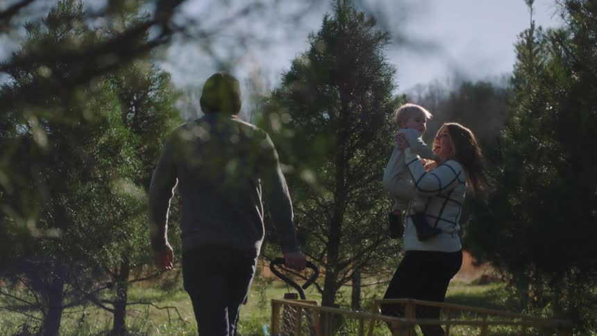 A family walking out in a forest together with a cart